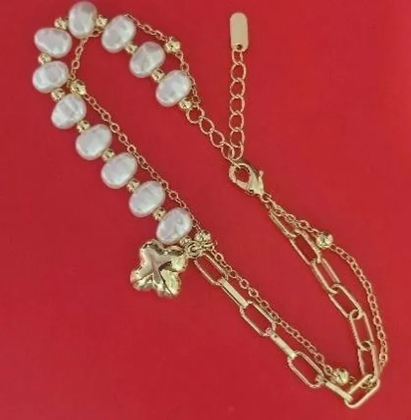 Pulsera dorada con perlas y dije de flor
