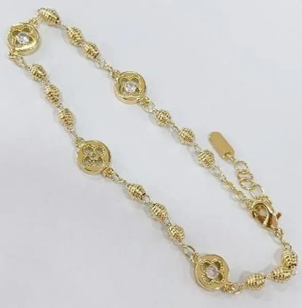Pulsera dorada con dijes de trébol y cristal